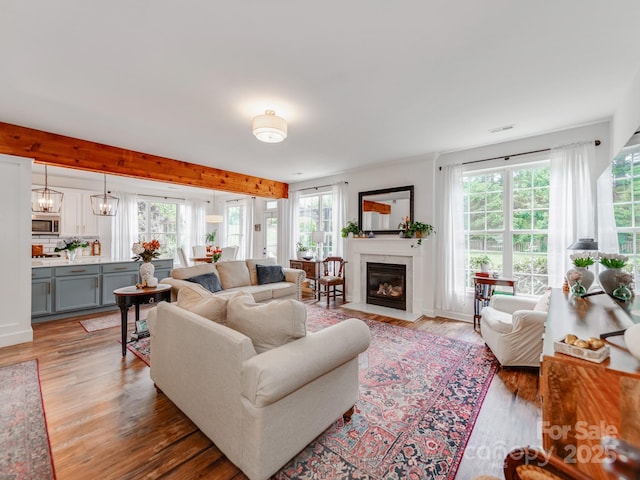 1605 Ambergate Dr, Waxhaw, NC 28173 - living area featuring plenty of natural light, light wood-style floors, a high end fireplace, and beamed ceiling