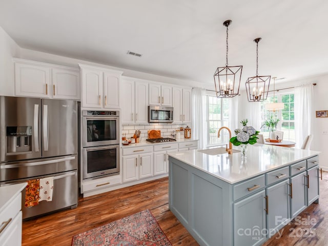 1605 Ambergate Dr, Waxhaw, NC 28173 - kitchen with appliances with stainless steel finishes, plenty of natural light, a chandelier, and white cabinets
