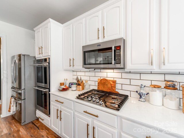 1605 Ambergate Dr, Waxhaw, NC 28173 - kitchen with stainless steel appliances, white cabinets, and tasteful backsplash