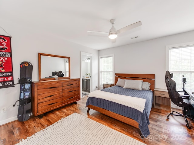 1605 Ambergate Dr, Waxhaw, NC 28173 - bedroom featuring multiple windows, wood finished floors, a ceiling fan, and ensuite bath