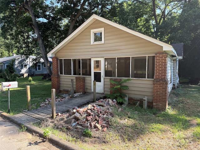 310 E Division Ave, East Spencer, NC 28039 - bungalow with brick siding, a front lawn, and a sunroom