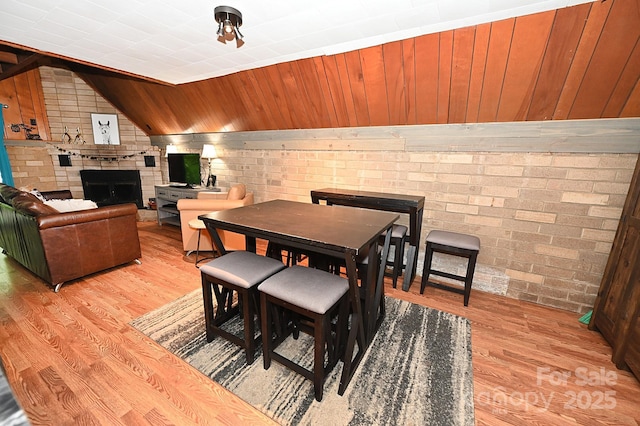3430 Rose Creek Rd, Morganton, NC 28655 - dining room featuring wood finished floors, brick wall, a fireplace, and wood walls