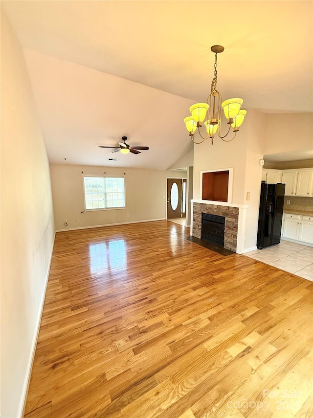 4351 Grover Pl, Granite Falls, NC 28630 - unfurnished living room featuring light wood-type flooring, a chandelier, a ceiling fan, vaulted ceiling, and a fireplace