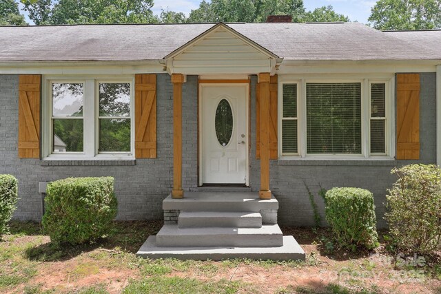 435 Stirewalt Rd, China Grove, NC 28023 - property entrance with brick siding, a chimney, and roof with shingles