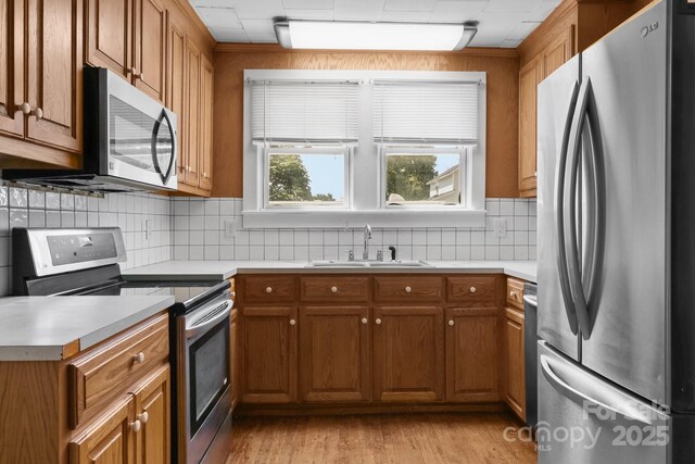 435 Stirewalt Rd, China Grove, NC 28023 - kitchen featuring appliances with stainless steel finishes, brown cabinets, decorative backsplash, and light countertops