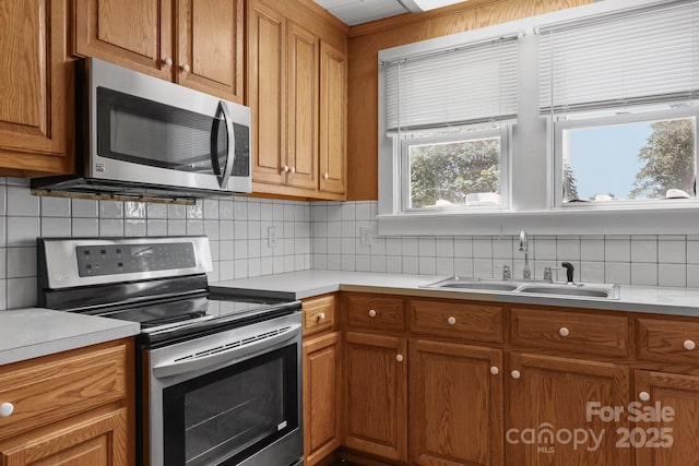435 Stirewalt Rd, China Grove, NC 28023 - kitchen featuring appliances with stainless steel finishes, brown cabinetry, decorative backsplash, and light countertops