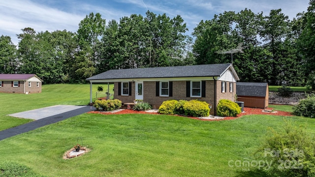 1040 Stagecoach Trl, Lenoir, NC 28645 - ranch-style home featuring brick siding, a front yard, an outdoor structure, a fire pit, and view of wooded area