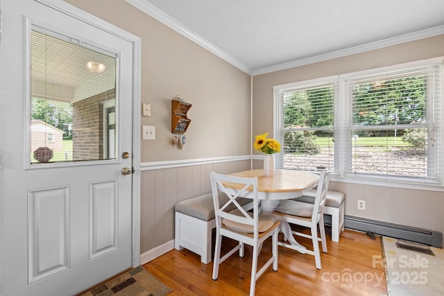 1040 Stagecoach Trl, Lenoir, NC 28645 - dining room featuring wood finished floors, crown molding, baseboard heating, and a wainscoted wall