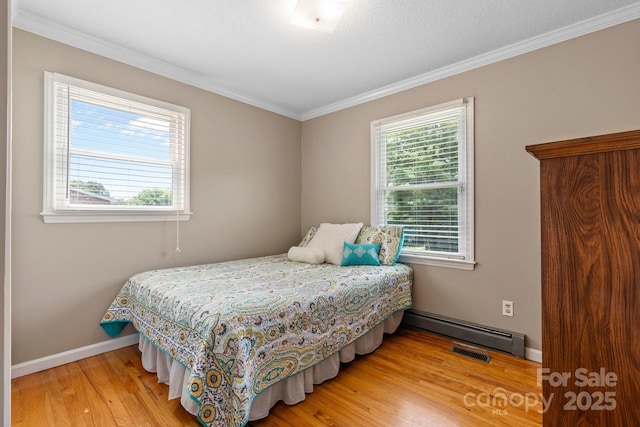 1040 Stagecoach Trl, Lenoir, NC 28645 - bedroom with a baseboard heating unit, crown molding, and wood finished floors