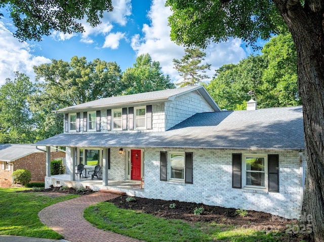 310 25th Ave NW, Hickory, NC 28601 - view of front of house featuring covered porch, brick siding, a chimney, roof with shingles, and a front yard