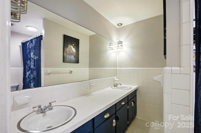 310 25th Ave NW, Hickory, NC 28601 - bathroom with tile walls, double vanity, and a wainscoted wall