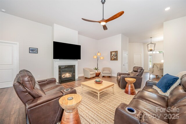 7739 Village Pkwy, Locust, NC 28097 - living area featuring wood finished floors, ceiling fan, a fireplace with flush hearth, a chandelier, and recessed lighting