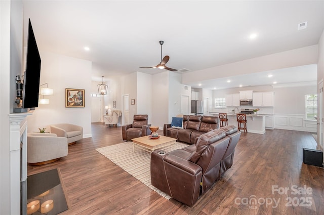7739 Village Pkwy, Locust, NC 28097 - living room featuring dark wood-type flooring, a ceiling fan, and a decorative wall