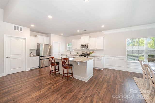 7739 Village Pkwy, Locust, NC 28097 - kitchen with stainless steel appliances, plenty of natural light, a breakfast bar area, an island with sink, and recessed lighting