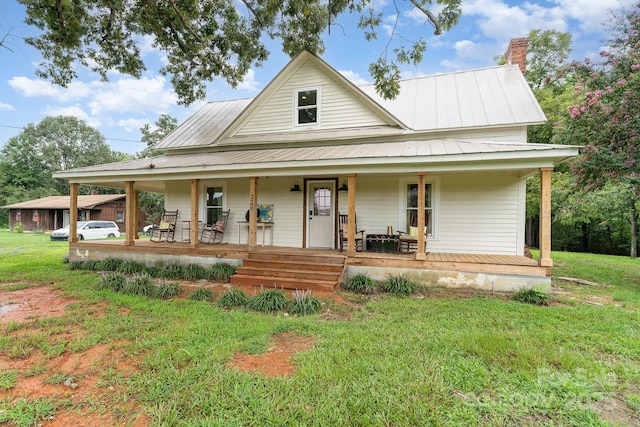 220 Low Water Bridge Rd, Troy, NC 27371 - country-style home with a porch, a front yard, a metal roof, and a chimney