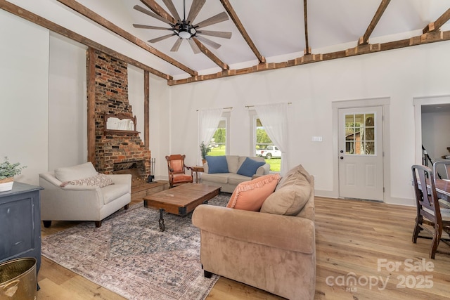 220 Low Water Bridge Rd, Troy, NC 27371 - living room featuring ceiling fan, light wood-style flooring, beam ceiling, a brick fireplace, and high vaulted ceiling
