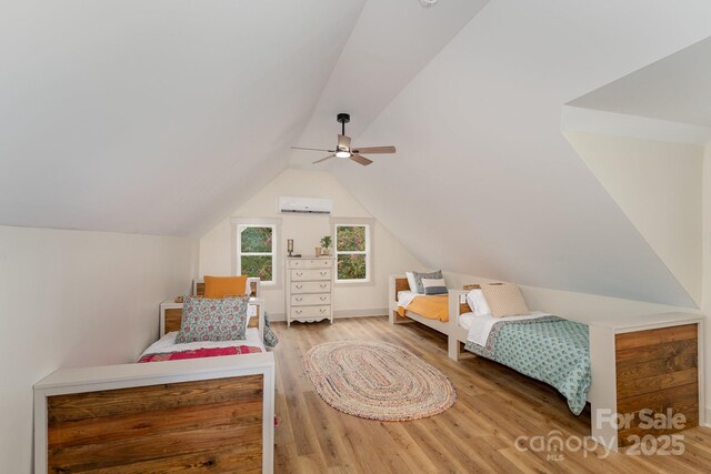220 Low Water Bridge Rd, Troy, NC 27371 - bedroom featuring a wall unit AC, wood finished floors, lofted ceiling, and a ceiling fan