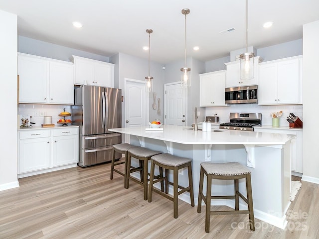 4268 Coachwhip Ave, Lancaster, SC 29720 - kitchen with stainless steel appliances, light wood-style flooring, decorative backsplash, light countertops, and white cabinets