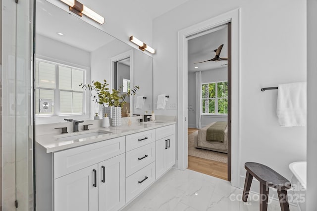3949 Plainview Rd, Charlotte, NC 28208 - bathroom featuring double vanity, marble look tiles, a ceiling fan, and connected bathroom