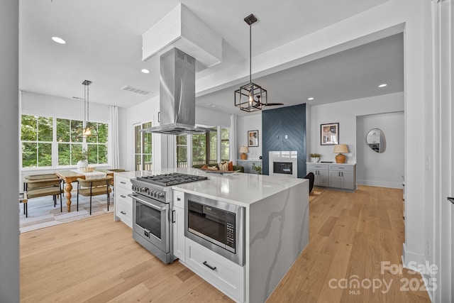 3949 Plainview Rd, Charlotte, NC 28208 - kitchen featuring stainless steel appliances, island exhaust hood, a chandelier, light wood-style floors, and recessed lighting