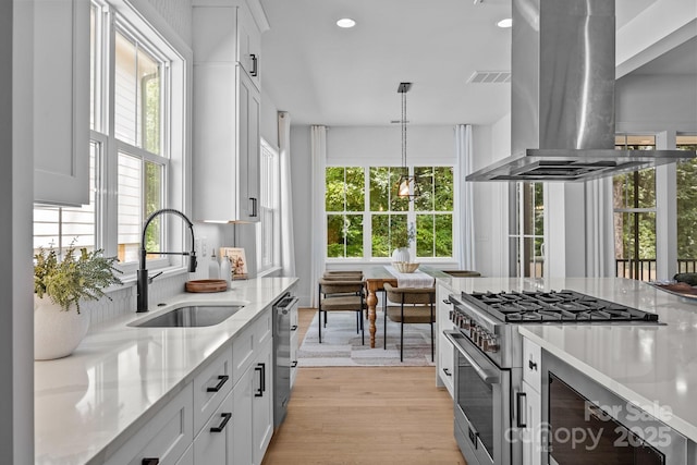 3949 Plainview Rd, Charlotte, NC 28208 - kitchen with wall chimney exhaust hood, appliances with stainless steel finishes, healthy amount of natural light, light stone countertops, and recessed lighting
