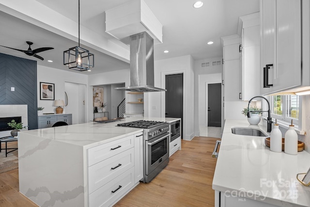 3949 Plainview Rd, Charlotte, NC 28208 - kitchen featuring stainless steel range, island range hood, built in microwave, white cabinetry, and recessed lighting