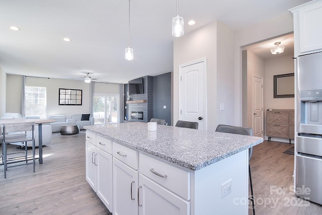 4017 Avis Way, Monroe, NC 28110 - kitchen with ceiling fan, a kitchen island, a kitchen breakfast bar, light wood-style floors, and stainless steel fridge with ice dispenser