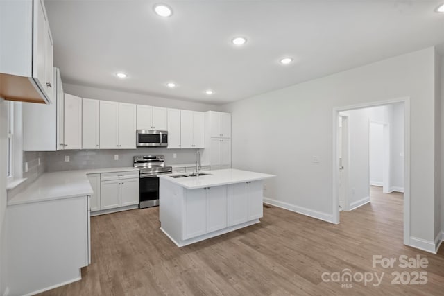 164 Meadow Glen Dr, Troutman, NC 28166 - kitchen featuring stainless steel appliances, light wood-style flooring, light countertops, white cabinetry, and recessed lighting