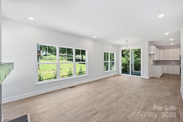 164 Meadow Glen Dr, Troutman, NC 28166 - unfurnished living room with a chandelier, light wood finished floors, and recessed lighting