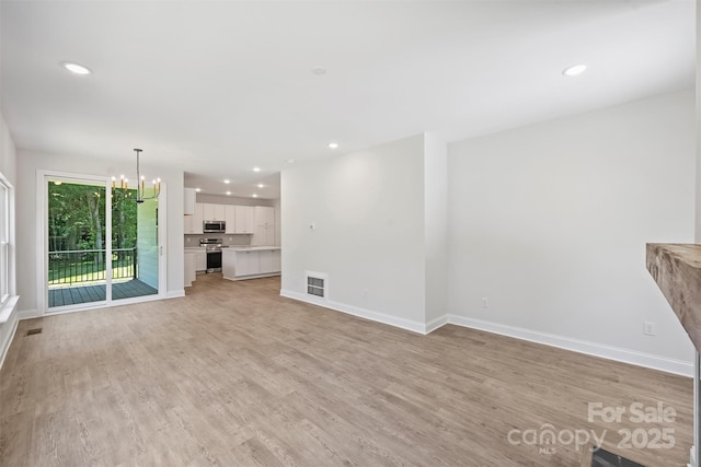 164 Meadow Glen Dr, Troutman, NC 28166 - unfurnished living room with a chandelier, recessed lighting, and light wood-type flooring