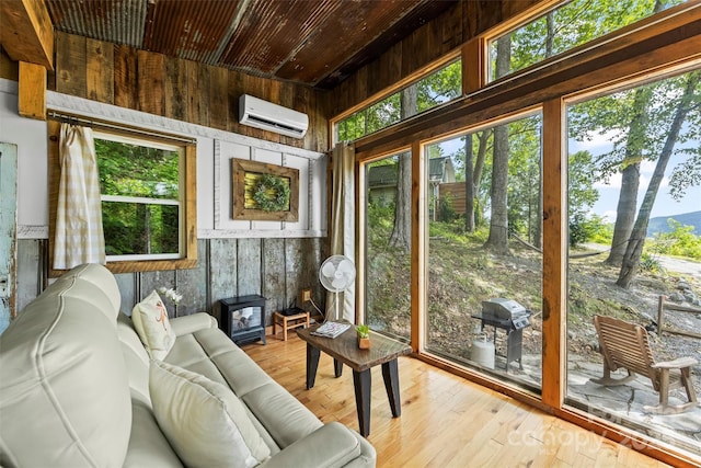 553 Paradise Mountain Rd, Canton, NC 28716 - sunroom featuring a wall mounted AC, a wood stove, and plenty of natural light
