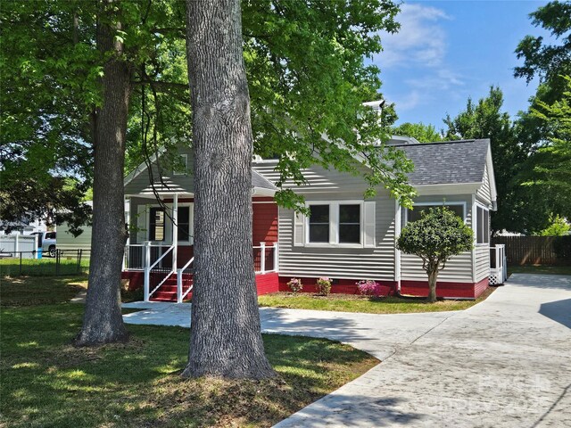 3824 Freedom Dr, Charlotte, NC 28208 - obstructed view of property featuring roof with shingles, a porch, and driveway