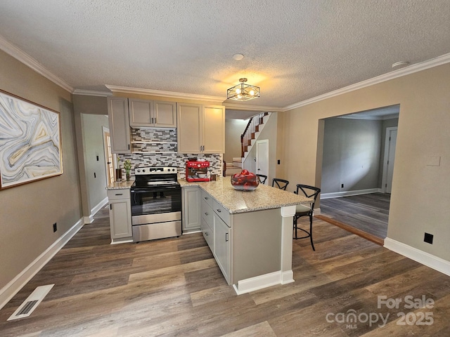 3824 Freedom Dr, Charlotte, NC 28208 - kitchen featuring electric range, a peninsula, dark wood-style floors, a textured ceiling, and tasteful backsplash