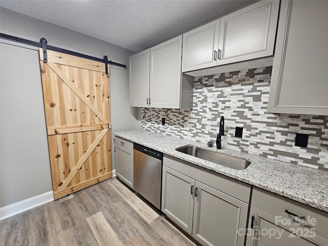 3824 Freedom Dr, Charlotte, NC 28208 - kitchen with stainless steel dishwasher, light wood-style floors, backsplash, light stone counters, and gray cabinets