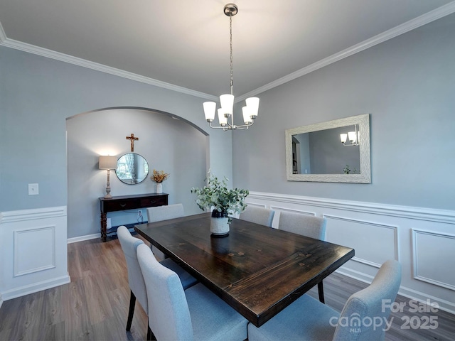 1324 Mona Vale Dr, Huntersville, NC 28078 - dining room featuring a chandelier, crown molding, wood finished floors, wainscoting, and arched walkways