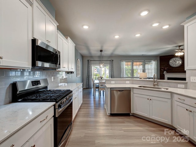 1324 Mona Vale Dr, Huntersville, NC 28078 - kitchen with stainless steel appliances, light wood-style floors, decorative backsplash, recessed lighting, and ceiling fan