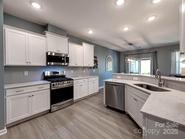 1324 Mona Vale Dr, Huntersville, NC 28078 - kitchen with stainless steel appliances, white cabinetry, light wood-style floors, tasteful backsplash, and recessed lighting