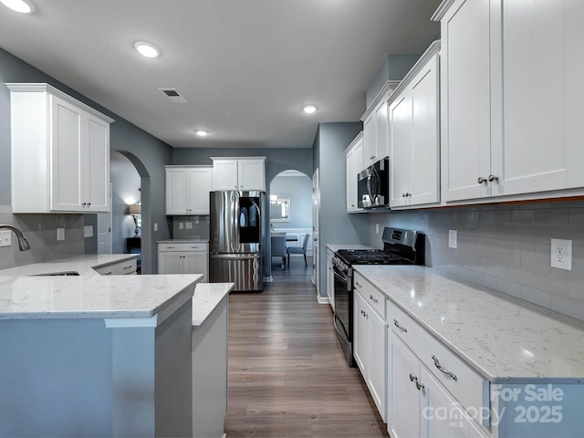 1324 Mona Vale Dr, Huntersville, NC 28078 - kitchen with stainless steel appliances, arched walkways, backsplash, a peninsula, and recessed lighting