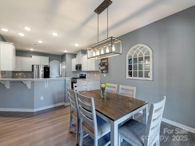 1324 Mona Vale Dr, Huntersville, NC 28078 - dining area featuring wood finished floors, arched walkways, and recessed lighting