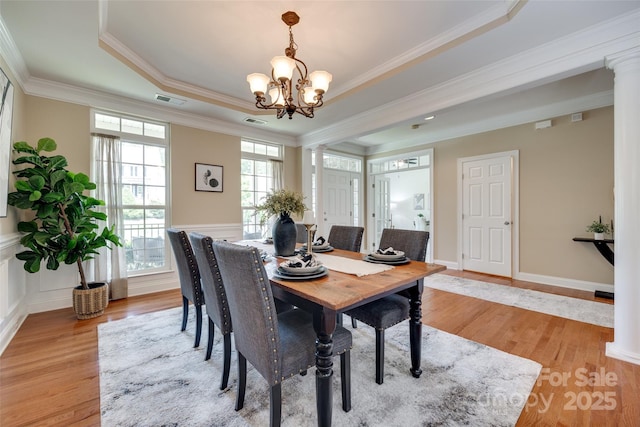 3905 Hounslow Ln, Harrisburg, NC 28075 - dining area with light wood finished floors, decorative columns, a chandelier, ornamental molding, and a raised ceiling