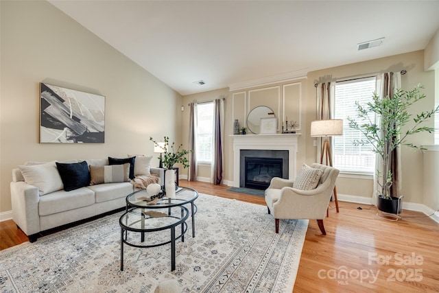 3905 Hounslow Ln, Harrisburg, NC 28075 - living room with a fireplace with flush hearth, light wood finished floors, and vaulted ceiling