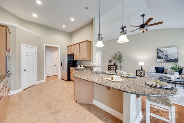 3905 Hounslow Ln, Harrisburg, NC 28075 - kitchen with light brown cabinets, high vaulted ceiling, a breakfast bar area, stainless steel fridge with ice dispenser, and a peninsula