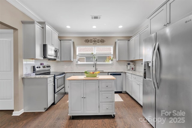282 Harrison Ln, Locust, NC 28097 - kitchen with appliances with stainless steel finishes, ornamental molding, dark wood-type flooring, backsplash, and a kitchen island