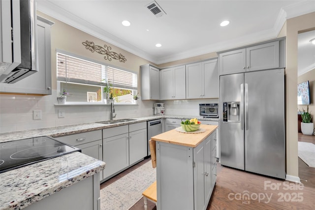282 Harrison Ln, Locust, NC 28097 - kitchen featuring stainless steel appliances, ornamental molding, butcher block countertops, gray cabinets, and light wood-style floors