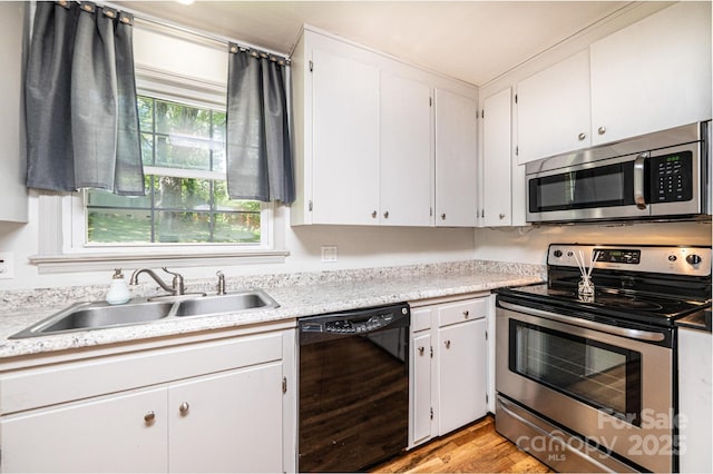 1036 11th Street Circle Dr NW, Hickory, NC 28601 - kitchen with appliances with stainless steel finishes, light countertops, light wood-style flooring, and white cabinets