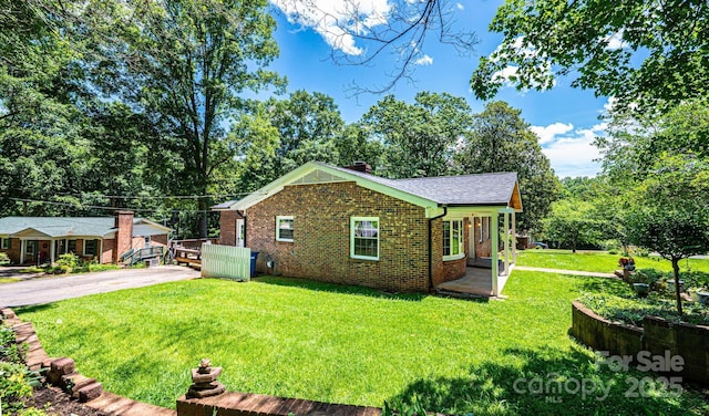 1036 11th Street Circle Dr NW, Hickory, NC 28601 - view of side of home with brick siding, a yard, a chimney, asphalt driveway, and roof with shingles