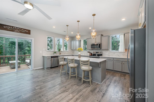 5499 Angus Dr, Midland, NC 28107 - kitchen featuring appliances with stainless steel finishes, gray cabinets, decorative backsplash, wood finished floors, and recessed lighting