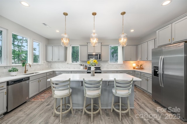 5499 Angus Dr, Midland, NC 28107 - kitchen featuring appliances with stainless steel finishes, gray cabinetry, a center island, decorative backsplash, and recessed lighting