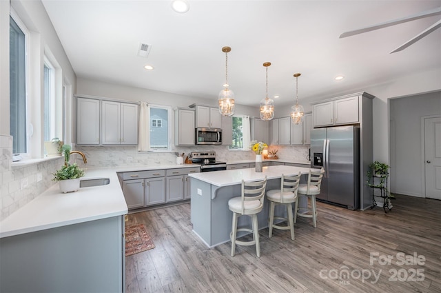 5499 Angus Dr, Midland, NC 28107 - kitchen with appliances with stainless steel finishes, gray cabinets, a kitchen island, decorative backsplash, and recessed lighting
