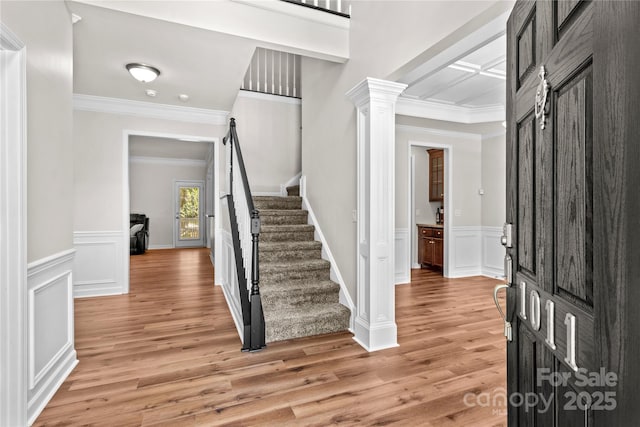 1011 Wadsworth Ln, Indian Trail, NC 28079 - foyer entrance with stairway, light wood finished floors, crown molding, decorative columns, and wainscoting